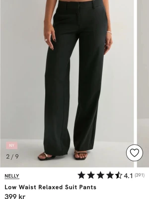 Svarta vida kostymbyxor  - Svarta low waist kostymbyxor med rak och lite vidare passform. Byxorna har en enkel design utan synliga detaljer och är perfekta för en avslappnad och stilren look. Materialet är lätt och luftigt, vilket gör dem sköna att bära.