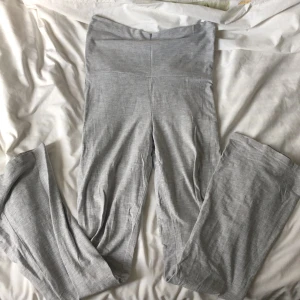 Yogapants - Säljer ett par ljusgrå leggings från Gina Tricot i mjuk bomullsblandning. De har hög midja och en tight passform, perfekta för en avslappnad stil eller till träning. Superbekväma och stretchiga. De har en liten fläck på låret som dock går att täckas ifall man viker ner byxan.