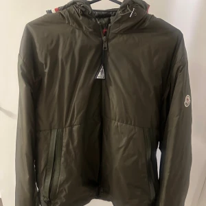 Mörkgrön Moncler Jacka - Säljer en Moncler jacka som jag köpte på NK för cirka 3 år sen , inga defekter och skulle säga 8/10 skick. Finns ej kvitto kvar men om du behöver fler bilder för att  legitchecka med kunniga folk så skickar jag fler bilder.