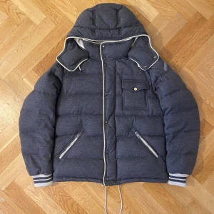 Moncler Bresle Giubbotto - Säljer en äkta Moncler dunjacka i en ovanligare och väldigt premium grå melerad ull/tyg-finish. Jackan är tjockt vadderad och extremt varm, perfekt för vinterväder. Klassisk Moncler-kvalitet med snygga detaljer och sportig men lyxig look.  100% ÄKTA (olagligt att sälja fakes)  Skick: Mycket fint begagnat skick! 2 små defekter som inte syns när man har på den. Defekterna ser ni på bilderna!  Storlek: 3=L men passar som M   Nypris: Betydligt högre (Moncler ligger normalt långt över 10 000 kr för l