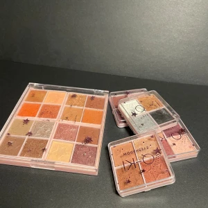 OKI ögonskuggspaletter i varma toner - Flera ögonskuggspaletter från OKI. Färgerna är varma och glittriga, med nyanser av orange, guld, koppar, rosa, beige, brunt och silver. Paletterna har stjärndetaljer i pudret och kommer i transparent plastförpackning med tryckta stjärnor. Är bara testade, men inte mina färger. 