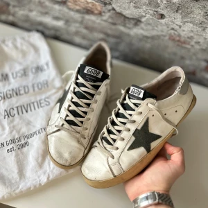 Golden goose superstar - Acceptabelt skick, heelcrease, sprucken vid hälen och allmänt dåligt skick - Därav priset. Nypris ca 5000kr. Storlek 43.  Dustbag medföljer inte. Självklart äkta - kolla bara recensionerna! Skriv för mer information🤝 