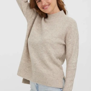 Beige stickad tröja Vero Moda - Mysig beige stickad tröja från Vero Moda med ribbad hög hals och breda ribbade muddar vid ärmslut och nederkant. Skriv vid frågor💕