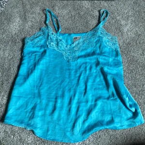 Turkos topp o shorts med spets från H&M - Supersöt turkos linnetopp o shorts från H&M med tunna axelband och v-ringning dekorerad med spets. Sättet är i storlek S men skulle även passa någon med M