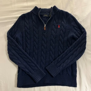 Marinblå kabelstickad tröja Polo Ralph Lauren - Marinblå kabelstickad halfzip från polo Ralph lauren. Riktigt snygg och riktigt skön speciellt nu när kalla vödret kommer. Storlek S.