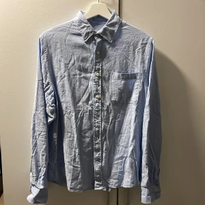 Ljusblå linneskjorta från Dressmann - Fräsch ljusblå skjorta från Dressmann i linnemix, perfekt för dig som gillar en chill och stilren look. Klassisk krage, bröstficka och knappar framtill. Långärmad och luftig passform som funkar året runt. Snygg att bära både uppknäppt och stängd.  Använd typ en gång då jag köpte den lite liten. Den är inte stryken!