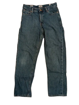 Mörk blå jeans från Jack & Jones - Klassiska blå jeans från Jack & Jones med relaxed fit och raka ben. Jeansen har fem fickor, bälteshällor och stängs med knapp och dragkedja. Tillverkade i slitstarkt denimtyg av bomull. Perfekta för en avslappnad och cool stil.