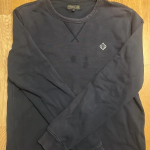 Mörkblå sweatshirt från Morris S - Snygg mörkblå Morris tröja, ända problem är att den har liten fläck i mitten av tröjan som ni ser på bilden annars är den jätte skön och snygg 