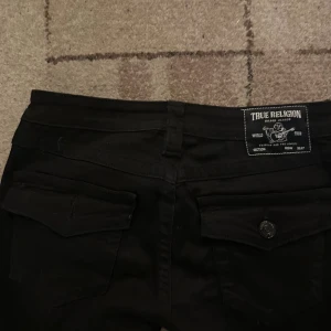 True Religion svarta bootcut jeans Joey 26 - Svarta jeans från True Religion, modell Joey med låg midja och bootcut. Använda 1 gång då jag köpte fel storlek. Köpta från Nelly köpta för 1300