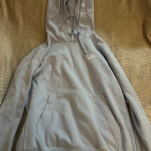 Nike hoodies i grått och ljusblått - Två snygga Nike hoodies, en i ljusblått och en i grått. Båda har huva med snörning, stor magficka och Nike-logga framtill. Perfekta för chill dagar eller när du vill ha en sportig look. Mjukt material och långärmade.