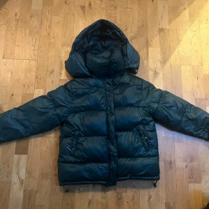 Mörkgrön pufferjacka/ vinterjacka med huva - Säljer en mörkgrön vinterjacka med stor, mysig huva och dragkedja framtill. Den är från Bikbok i Stolek xs (men passar även S/M) och perfekt nu till vintern💕💕snöret man hänger upp jackan med har gått av (se bild 5) men går att sy fast om man vill!💕💕💕