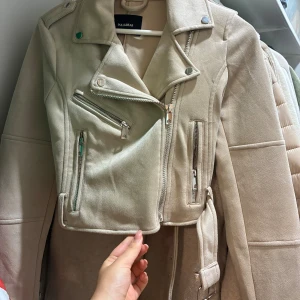 Beige mocka jacka - Beige mocka jacka som är croppad, nästan oanvänd, med bälte och sliver detaljer