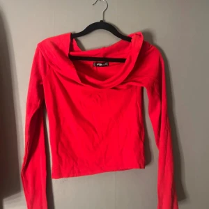 Röd långärmad topp från FB Sister - Säljer en snygg röd långärmad topp från FB Sister i storlek M. Toppen har en bred, draperad krage som ger en cool look och är tillverkad i mjuk bomull. Passformen är normal och färgen är riktigt klar röd, perfekt för att sticka ut.