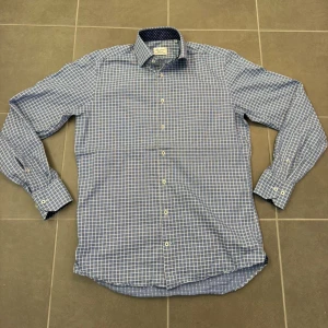 Blårutig skjorta från Stenströms stl 38 - Snygg blårutig skjorta från Stenströms i fitted body-modell. Skjortan har vita knappar, lång ärm och kontrasttyg soprickigt mönster på insidan av kragen. Tillverkad i mjuk tvåfaldig bomull som känns riktigt skön mot huden.