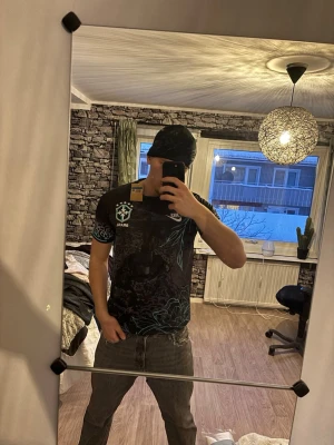 Nike Brasil svart t-shirt med leopardmönster - Säljer en svart Nike Brasil t-shirt med coolt leopardmönster på ärmarna och turkosa detaljer. Tryck med Kristusstatyn och grafiska blad på framsidan. Perfekt för dig som vill sticka ut med sportig vibe och snygg design.