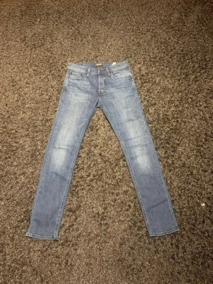 Jack and Jones mörkblå slim jeans 30/32 - Säljer ett par ljusblå skinny jeans från Jack and Jones  i storlek 30/32. Jeansen har klassisk femficksdesign, smal passform och är tillverkade i mjukt jeansmaterial. De passar till allt och ger dig en skönt avslappnad still. Hör av dig vid minsta fundering och pris kan diskuteras! 🙌