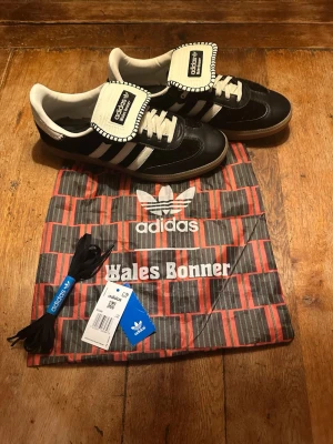 Adidas Samba Wales Bonner svart/vit 45 1/3 - Svarta Adidas Samba Wales Bonner sneakers i storlek 45 1/3. De är i mycket bra skick förutom lite vanliga creases. Jag skickar med påse, svarta snören, lappar. Det är futsal verisionen för de som undrar. Hör av dig vid frågor eller prisförslag!!