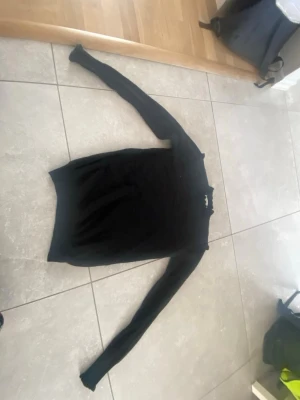 Svart stickad polotröja från Kaffe - Säljer en svart stickad polotröja från Kaffe i storlek XS. Tröjan har lång ärm och en hög krage med diskret volangkant. Perfekt för dig som gillar en enkel men ändå snygg look till höst och vinter.