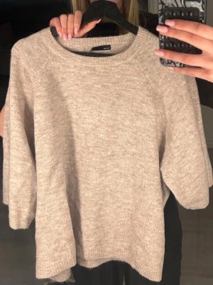 Beige stickad tröja med trekvartsärm - Mysig beige stickad tröja med trekvartsärmar. Tröjan har en avslappnad passform och är väldigt mjuk och skön!