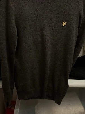 Mörkgrå stickad tröja från Lyle & Scott - Säljer en mörkgrå stickad tröja från Lyle & Scott, endast använd ett fåtal gånger och utan defekter. Perfekt för den som gillar enkla och stilrena plagg. Kan diskutera priset
