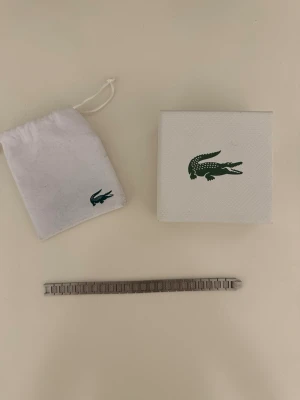 Lacoste armband  - Lacoste armband herr. Helt ny fick den av en vän. Passar inte mig behöver bli av med den. 