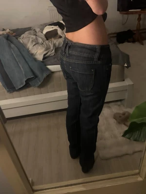 Mörkblå low waist jeans från Polar - Säljer ett par mörkblå jeans från Polar med låg midja och raka ben. Jeansen har dubbla knappar i midjan och kontrastsömmar. Går att sy ut till bootcut eller klippa till shorts midjemått tvärs över: 37cm grenmått: 18cm innerbenslängd: 77cm skriv till mig vid intresse eller om ni har någon fråga💞