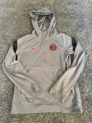 Grå PSG half zip - Stilig grå psg half zip från Nike i storlek 147-158 perfekt för dig som letar efter en stilig fotbollströja.