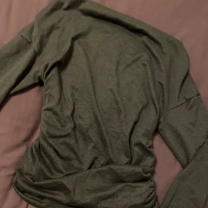 Svart långärmad tröja snedskuren uppe - En enkel och stilren svart långärmad tröja i mjukt material. Passar S/M/L för att det är stretchiga material.  