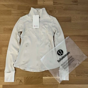 Lululemon jacket  - Lululemon jacka – storlek S passar delvis XS Helt ny med tag kvar. Aldrig använd, kommer i originalförpackning. Färg: Vit Superfin och bekväm – perfekt till träning eller vardag!