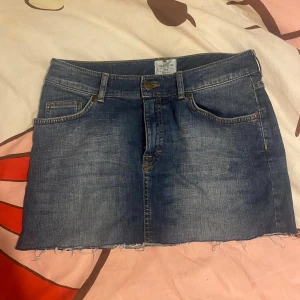 Blå jeanskjol från H&M L.O.G.G. - Säljer en mini jeans kjol i storlek 38. Perfekt till sneakers eller boots för en cool look.