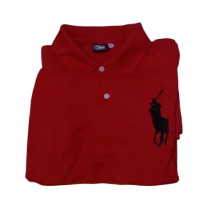 Ralph lauren polo - Snygg och klassisk pikétröja från Polo Ralph Lauren i starkt röd färg. Modellen har två vita knappar och den ikoniska stora svarta polospelaren broderad på bröstet. På ena ärmen finns siffran "3" svart.                                                                                  Längd 70cm Bred 50cm Storlek: L (herrmodell)                                             Röd med svarta detaljer Skick mycket bra använd sparsamt inga hål eller fläkar Hör av er vid frågor
