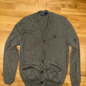 Polo Ralph Lauren Merino Ull Cardigan - Riktigt stilig och fräsch polo ralph lauren cardigan i 100% merino ull - lite ernstberger vibes! Mycket bra skick men en knapp har dessvärre lossnat, annars inga defekter! M men kan passa like olika! Skriv vid vad som! ✌️