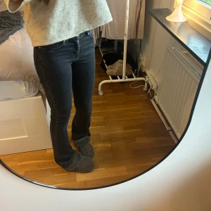 Svarta low flare jeans XS - Snygga svarta jeans med låg midja och flare-ben. Modellen är tight upptill och släpper ut nedtill.