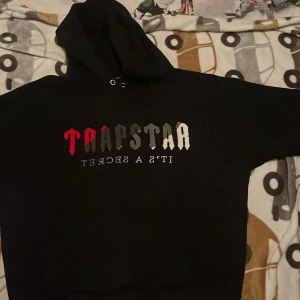Svart Trapstar hoodie med tryck - Svart hoodie från Trapstar, de storlek L och säljer den då jag ej använder den. OBS byte funkar. 