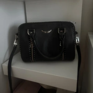 Zadig sunnybag - Intressekoll/säljer min så så fina Zadig väska!! Fick i present så finns tyvärr inget kvitto men dustbag och ett kort medföljer💕super fint skick men färgen på vissa silverkulor har lossnat (se bild) men inget man tänker på om man inte kollar noggrant❣️Finns även ett innerfack med dragkedjas och axelbandet går att ta av och reglera 🥰Höe av er vid frågor eller annat❣️❣️