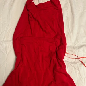 Röd ärmlös topp med halterneck - Snygg röd topp med halterneck och ärmlös design. Toppen har en tight passform och är tillverkad i ett mjukt, stretchigt material som sitter skönt mot kroppen. Perfekt för dig som vill sticka ut med en enkel men iögonfallande look. Denna fina toppen sticker även ut av färgen, den är rygglös och passar perfekt till jul som börjar närma sig. 🧑‍🎄
