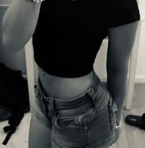 Lågmidjade ljusblå jeansshorts - Säljer ett par riktigt snygga lågmidjade jeansshorts i ljusblå denim. De har klassisk femficksdesign, korta ben och coola slitningar. Perfekta för varma sommardagar och ger en trendig vibe.