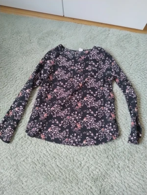 Supersöt barnblus - Super gullig barnblus i svart med mönster av rosa blommor och rådjur. I barnstorleken 134-140, skulle säga xxxs eller xxs i vuxenstorlek. Sparsamt använd 