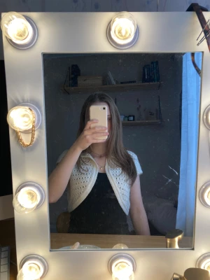 Vit stickad väst från Miss Selfridge - Säljer en kort, vit stickad väst från Miss Selfridge. Västen har ett öppet mönster och är croppad med korta ärmar. Perfekt att slänga över en topp. Stickad i mjukt garn och har en snygg, enkel design. Den går att knäppa upptill om man vill det