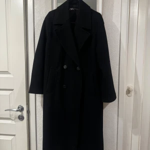Svart lång kappa från Zara - Klassisk svart kappa från Zara. Lösare i modellen. Använd en säsong, därav lite nopprig. Hör av dig om du vill se fler bilder! 
