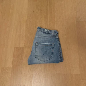 Blå jeans från Dondup George Med Slitningar - Snygga blå jeans från Dondup Limited Edition med klassisk femficksdesign och ljusa slitningar framtill. Jeansen har slim passform och normal midja, tillverkade i mjukt denimtyg för en bekväm känsla. Perfekt för dig som gillar stilrena och coola jeans med riktigt snygga slitningar.  Nypris 3400-4000 priset är diskuterbart, hör av dig vid frågor kring hur de sitter på osv!👌