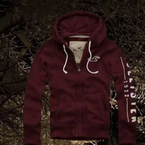 Hollister Zip Hoodie - Snygg vinröd hollister zip hoodie i storlek M, den är i topp skick och de finns inga defekter eller skador. Den är riktigt snygg och väldigt sällsynt samt trendig. 