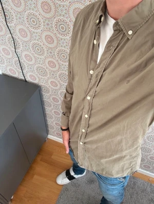 Oliv grön skjorta från Morris, storlek S - Snygg skjorta från Morris med klassisk krage och vita knappar hela vägen. Skjortan är långärmad och har en stilren, enkel design utan mönster. Perfekt till jeans för en riktigt snygg look!!! Skriv om ni har nån fråga och ge prisförslag!!!