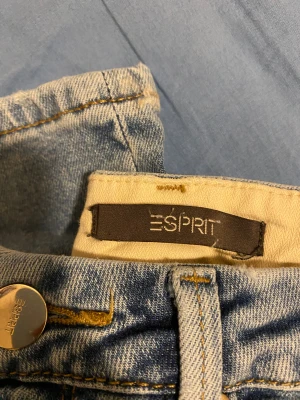 Blå jeans från Esprit - Snygga ljusblå jeans från Esprit med klassisk femficksdesign och guldfärgade sömmar. Jeansen har en normal passform och är tillverkade i slitstarkt denimtyg. Perfekt för dig som gillar en enkel och tidlös stil.
