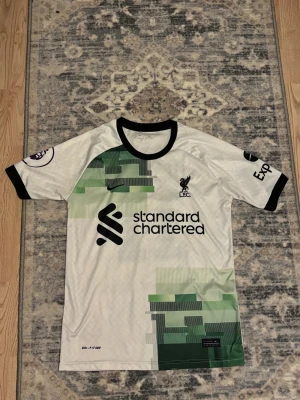 Liverpool fotbollströja  - Snygg liverpool FC bortatröja med M. Salah och nummer 11 på ryggen. Köpt för några år sen men nästan aldrig använd. Nytt skick. Pris kan diskuteras vid snabb affär.