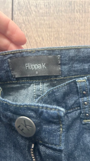 Mörkblå bootcut jeans med nitar - Snygga mörkblå jeans från Filippa K med bootcut passform och låg midja. Jeansen har dekorativa nitar på bakfickorna i Storlek s 