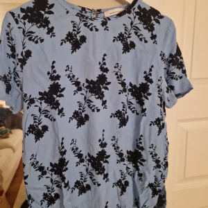 Blommig blus - Supersnygg blus i ljusblått med svart blommigt mönster från Samsøe Samsøe. Öppen för prisförslag!