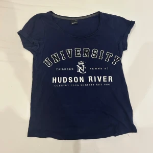 Marinblå t-shirt Hudson River Gina Tricot - Snygg marinblå t-shirt från Gina Tricot med vit tryckt text 'University Hudson River' på framsidan. I strl xs 