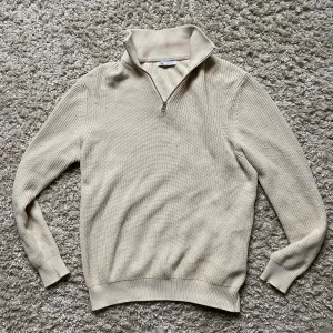 Beige stickad half zip-tröja från Zara - Säljer en beige stickad tröja från Zara med half zip-dragkedja. Skön och mjuk i materialet, perfekt för lager-på-lager.