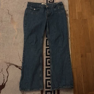 Blå bootcut jeans med fem fickor - Snygga blå jeans med klassisk femficksdesign och bootcut-ben. Jeansen har normal passform och är tillverkade i slitstarkt denimtyg. Perfekta för dig som gillar en tidlös och avslappnad stil.